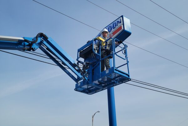OHM repairs an outdoor sign